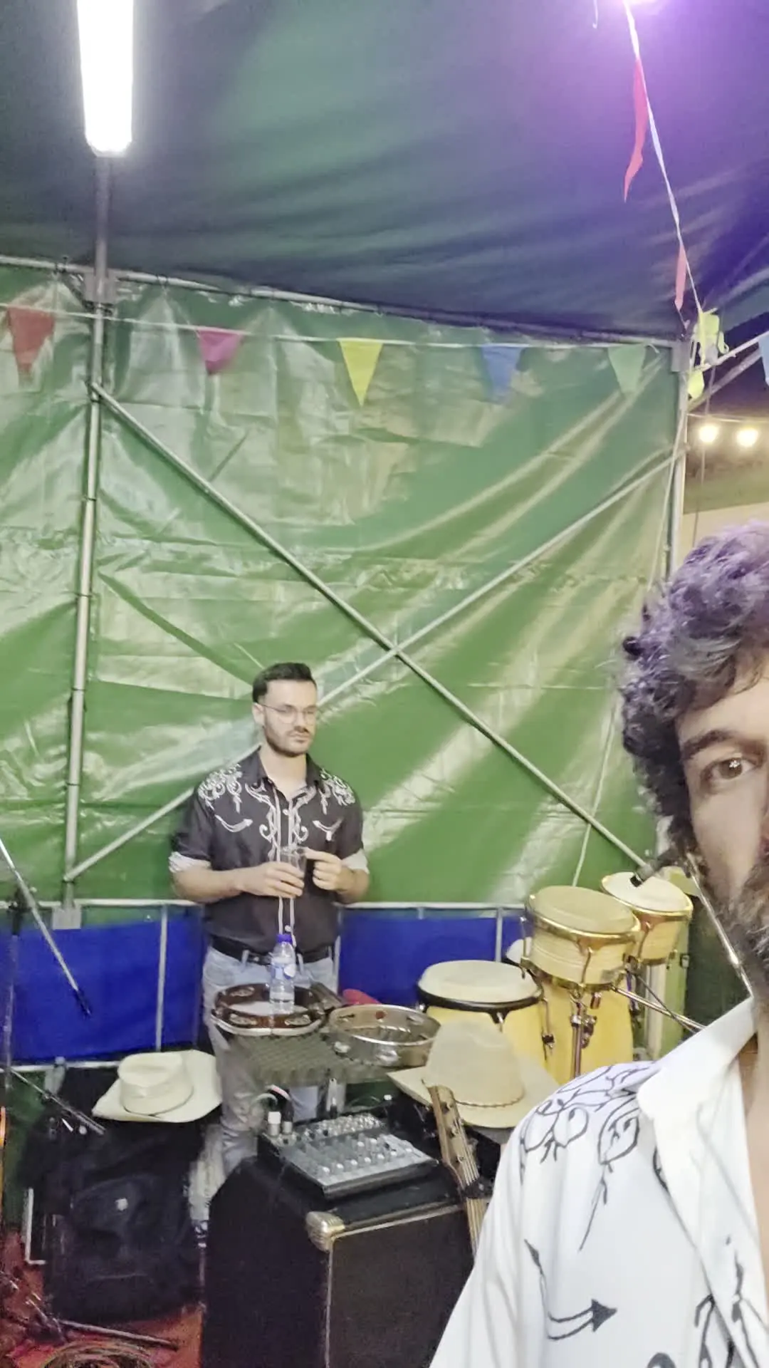 Palco com percussão, chapéus e bandeirinhas da festa.